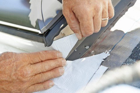 Man sealing the sides of the skylight
