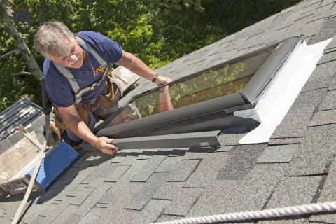 Man installs counterflashing on skylight