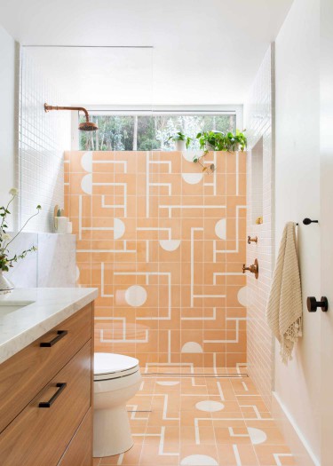 Regan Baker Design The Knolls master bath makeover with light orange wall and floor tiles.
