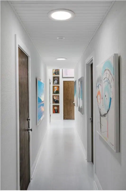 Hallway with bright natural light provided by two sun tunnels on the ceiling. 