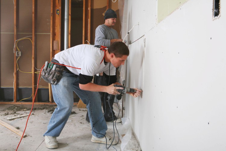 Drywall installers securing drywall