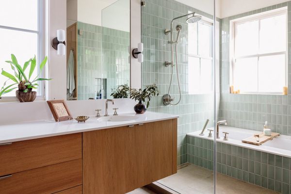 Bathroom with mint green glass tile and floating wood vanity