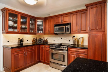 2000s cherry wood cabinets with dark granite countertops