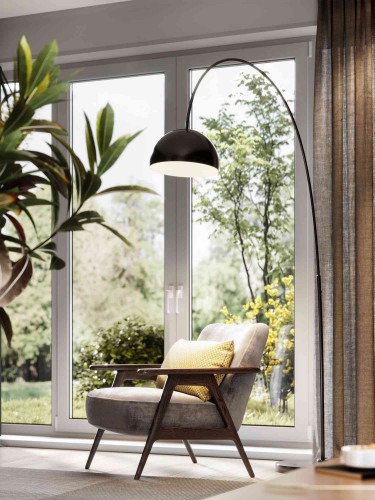 arm chair in living room with lamp and plant with big windows