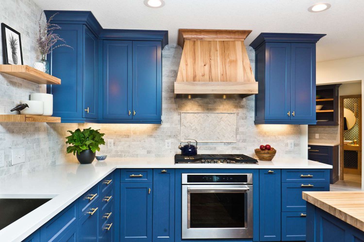 A large kitchen with navy blue painted cabinets and stainless steel appliances.