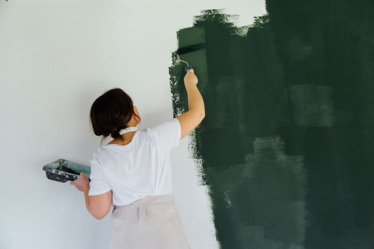 Woman painting a room green