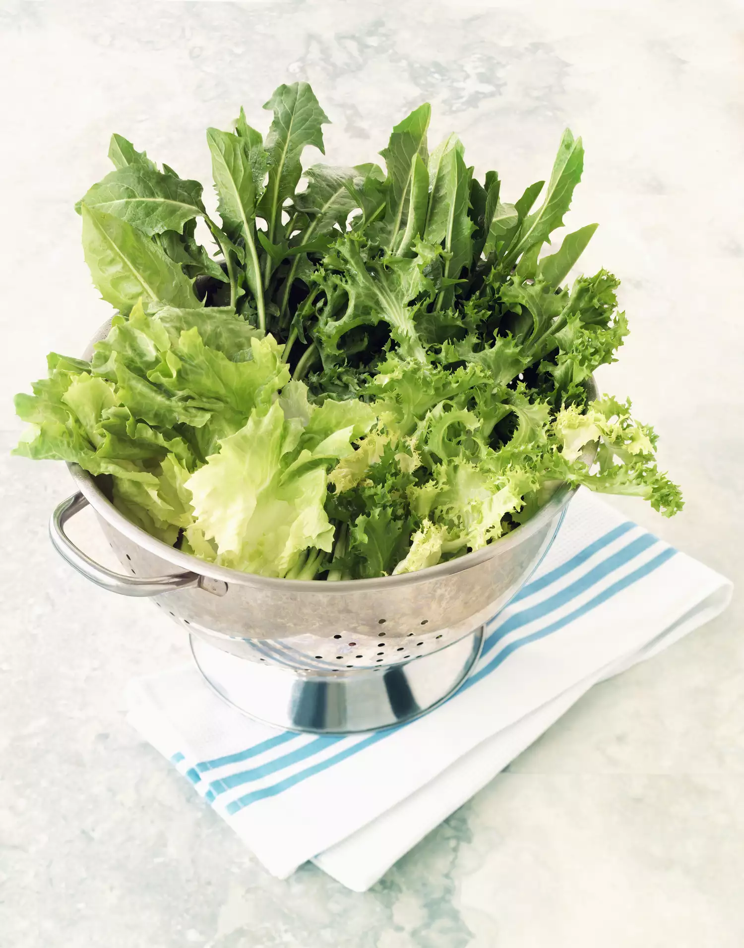 Colander filled with green lettuces.