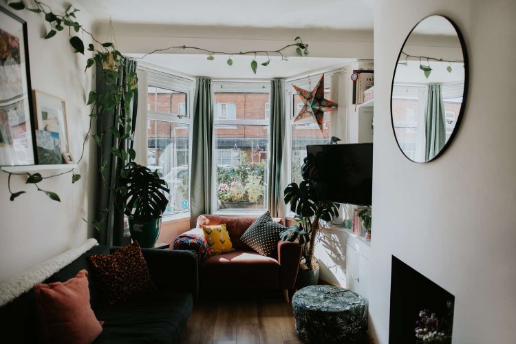 Crowded living room with small seat, footstool, and couch