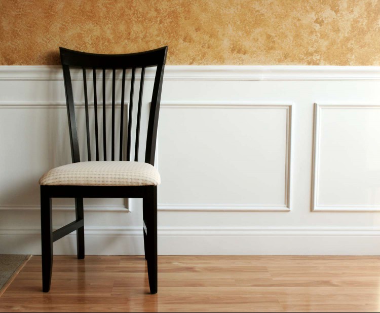 White wainscot panel with dining chair against it