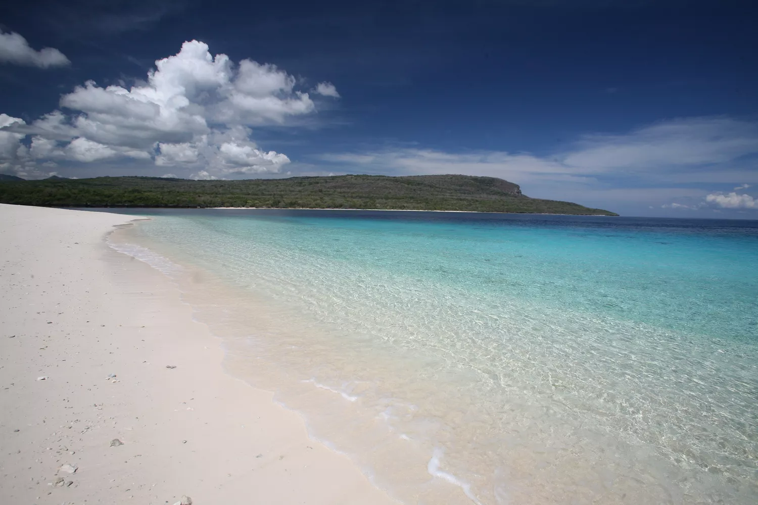 View of Jaco Island in the distance with white, sandy beach in the foreground