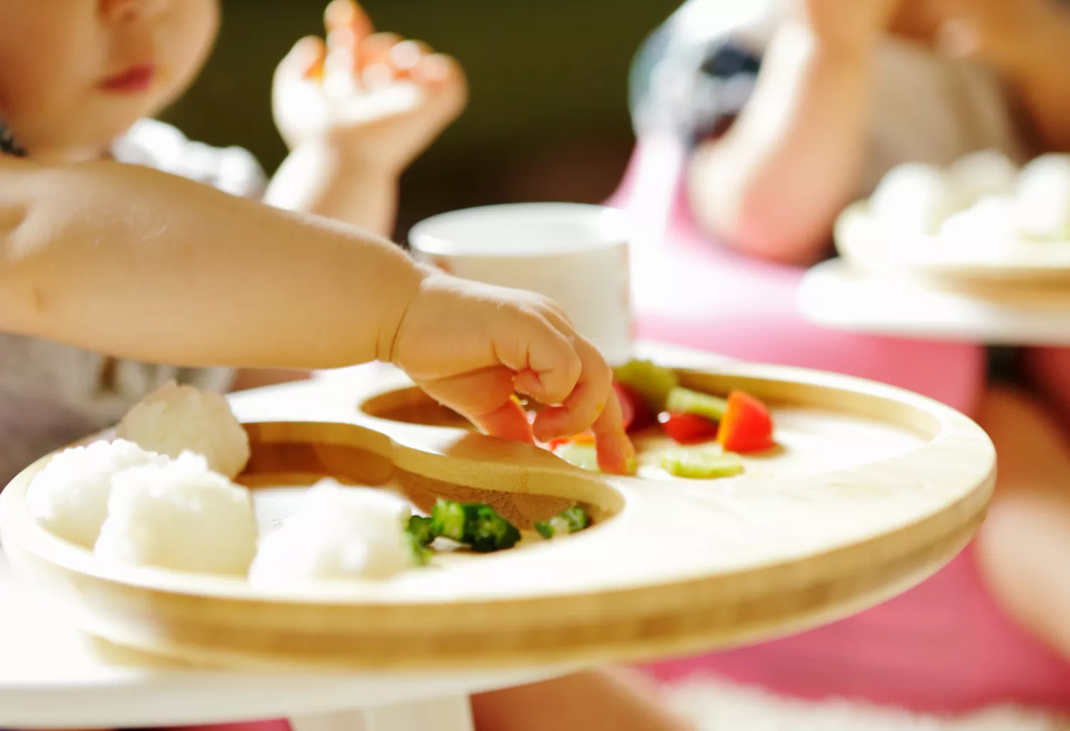 Little child eating meal with bare hands,close up