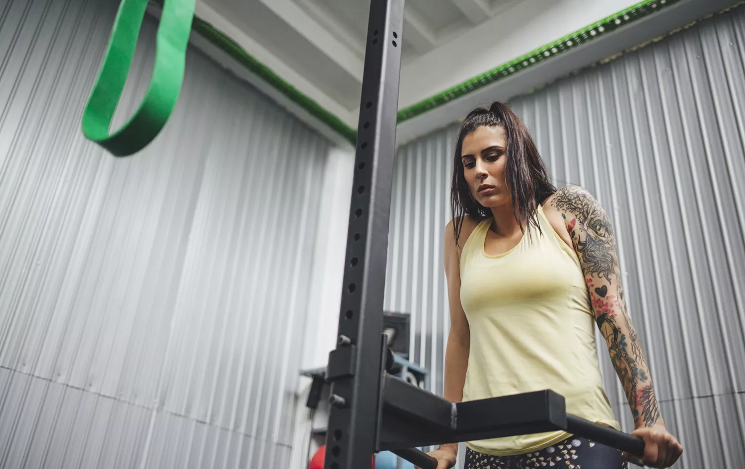 Low angle view of athlete exercising on dip machine in gym