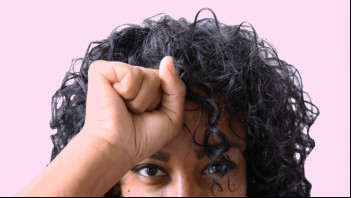 woman holding fist to forehead