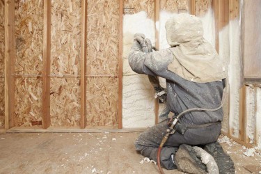 Spraying foam insulation into the wall