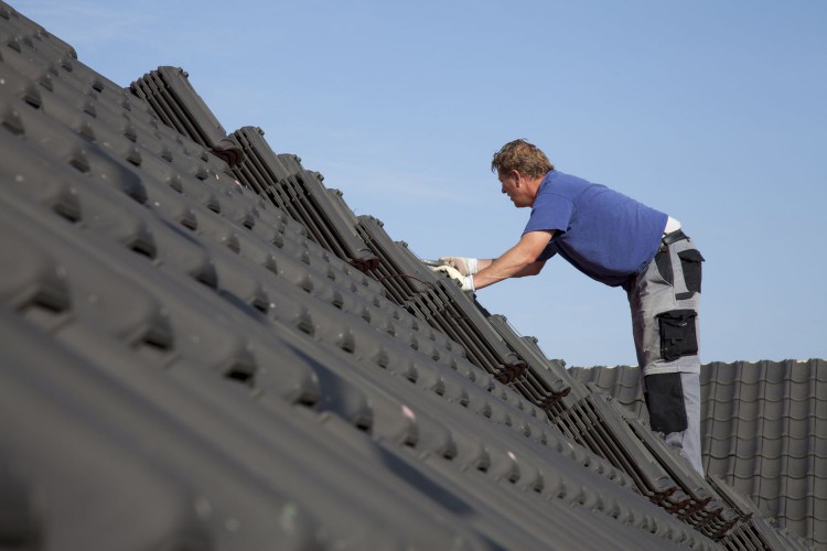 Roofers shingling a house
