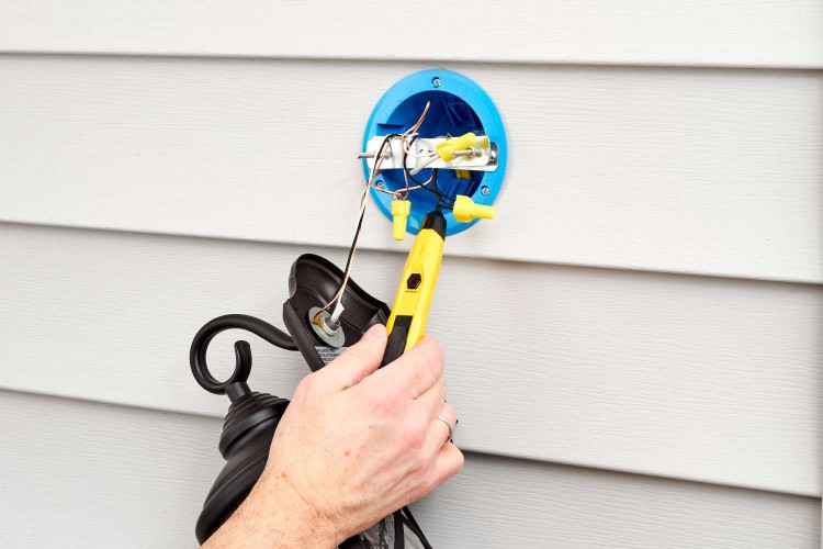 Using a voltage tester to make sure the power has been cut