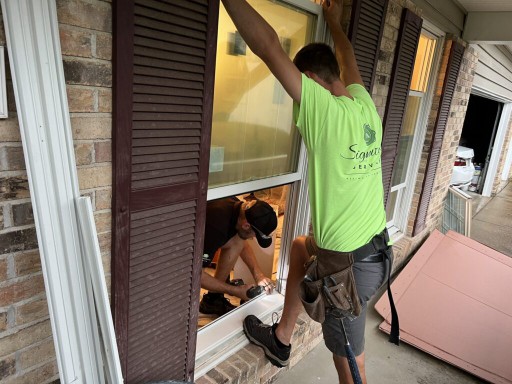 Window installation crew sealing replacement windows in home.