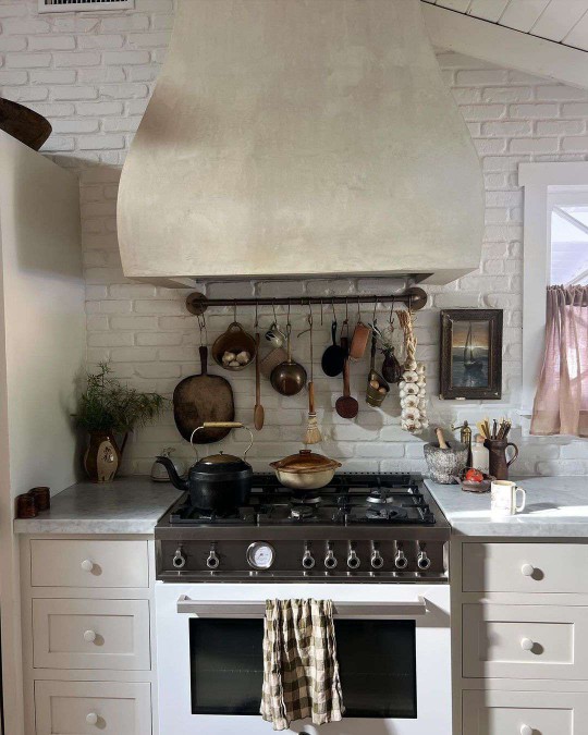 White farmhouse kitchen with white brick and antique kitchen tools 