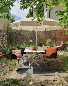 small patio with umbrella and colorful pillows
