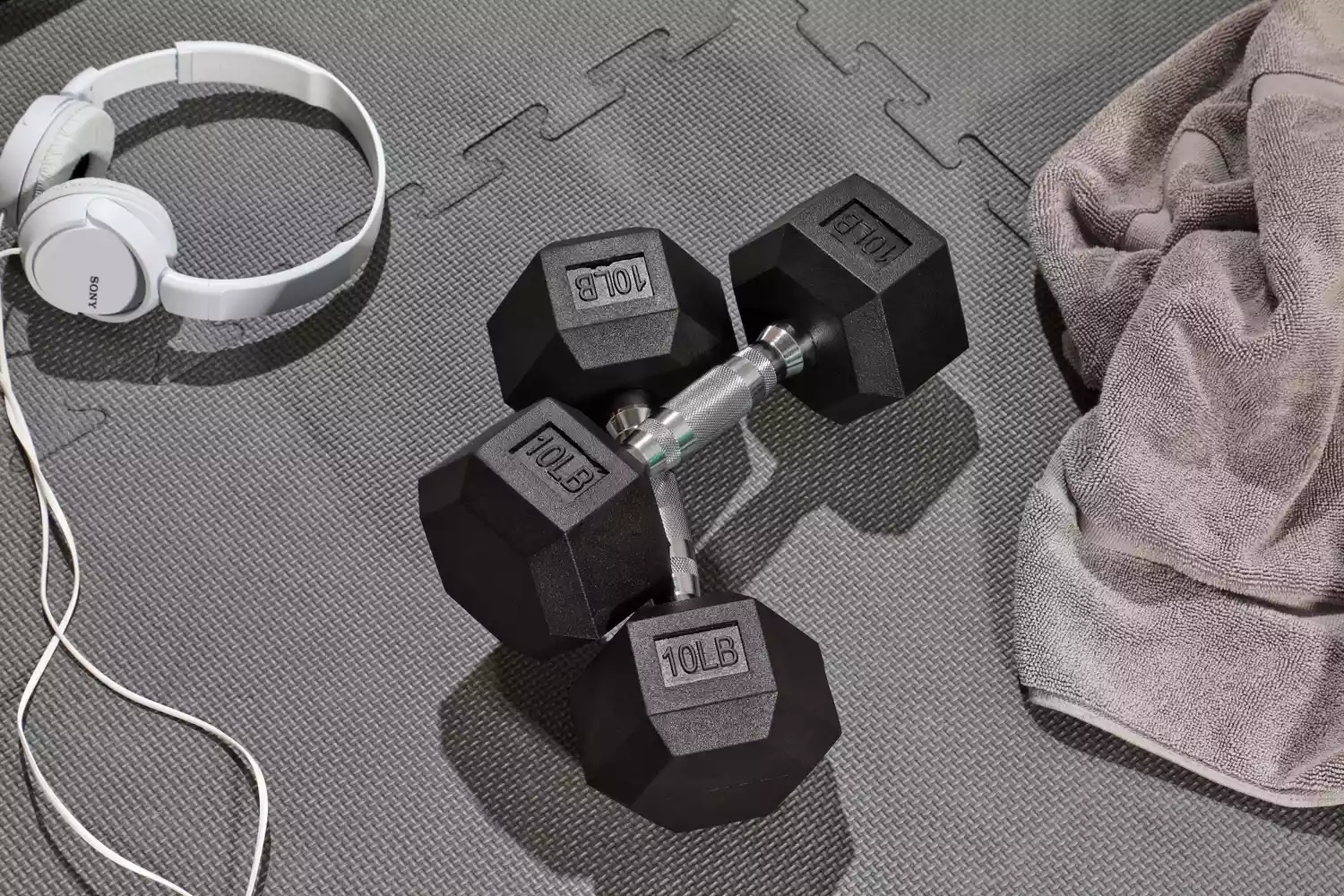 Two 10 pound BalanceFrom Rubber Encase Hex Dumbbells sitting crossed on an exercise mat