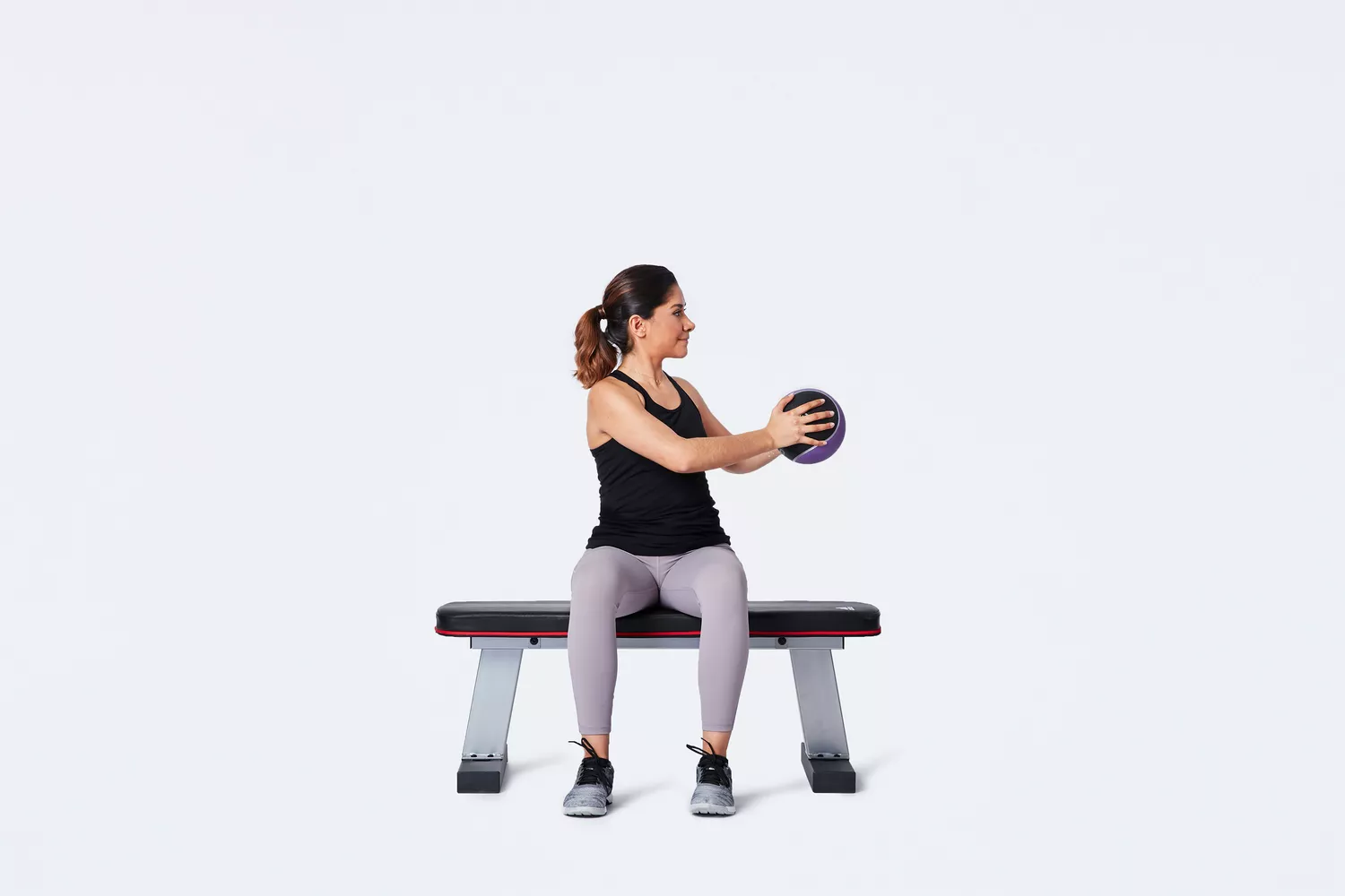 Woman sitting on a bench performing an ab rotation