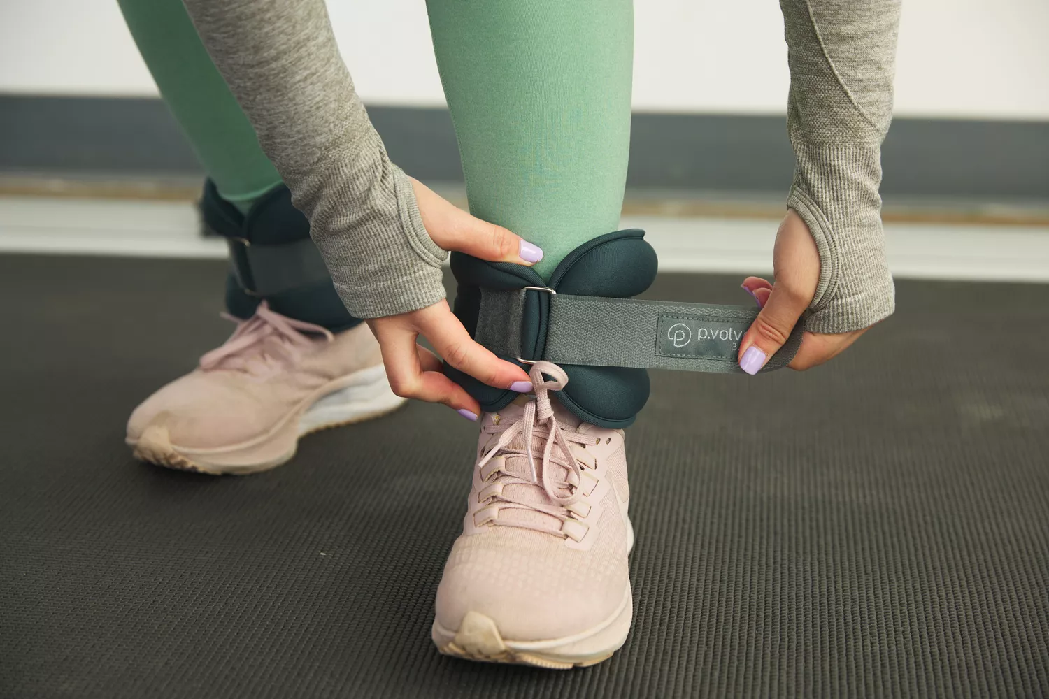 hands strapping a P Volve 3 LB Ankle Weight to ankle
