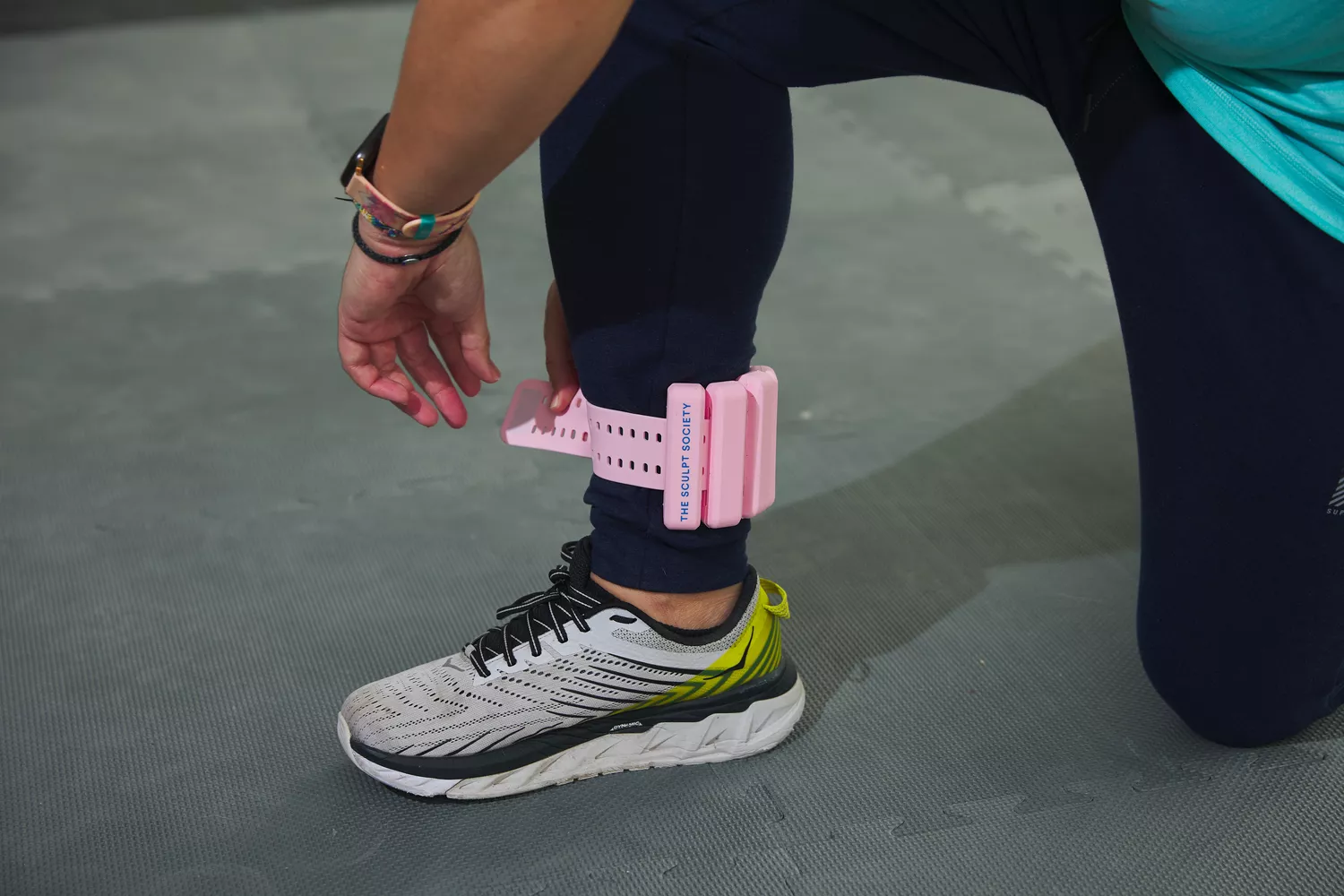 person strapping the The Sculpt Society 2 LB Weight to ankle