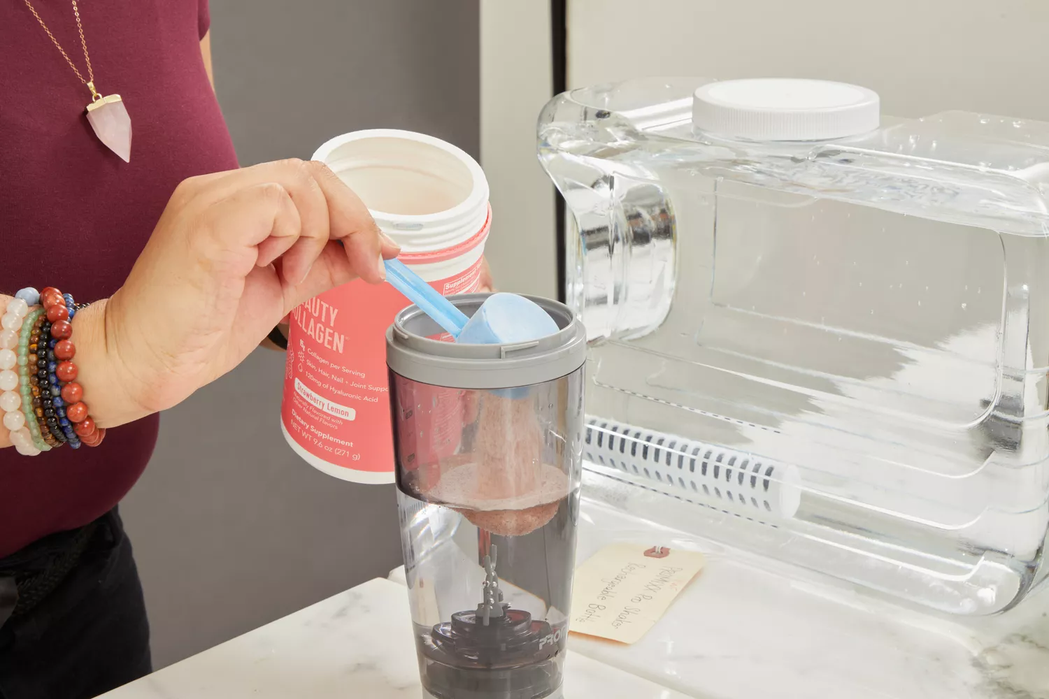 Person scooping powder into shaker bottle