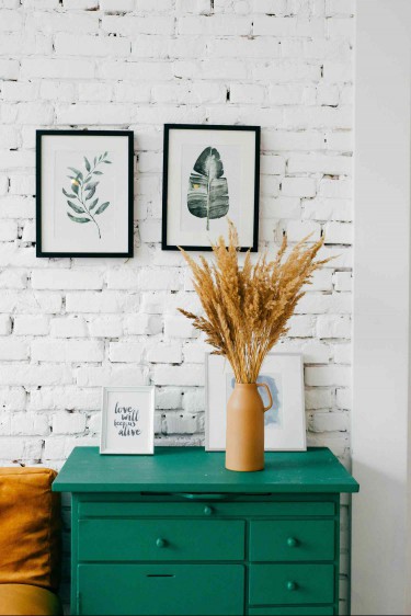 Unevenly spaced wall art on white brick wall