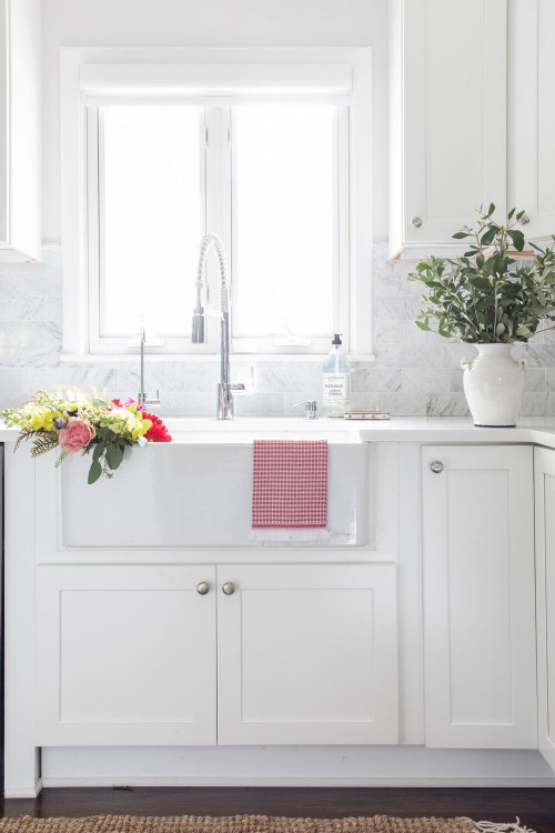 A white kitchen with faucet and sink
