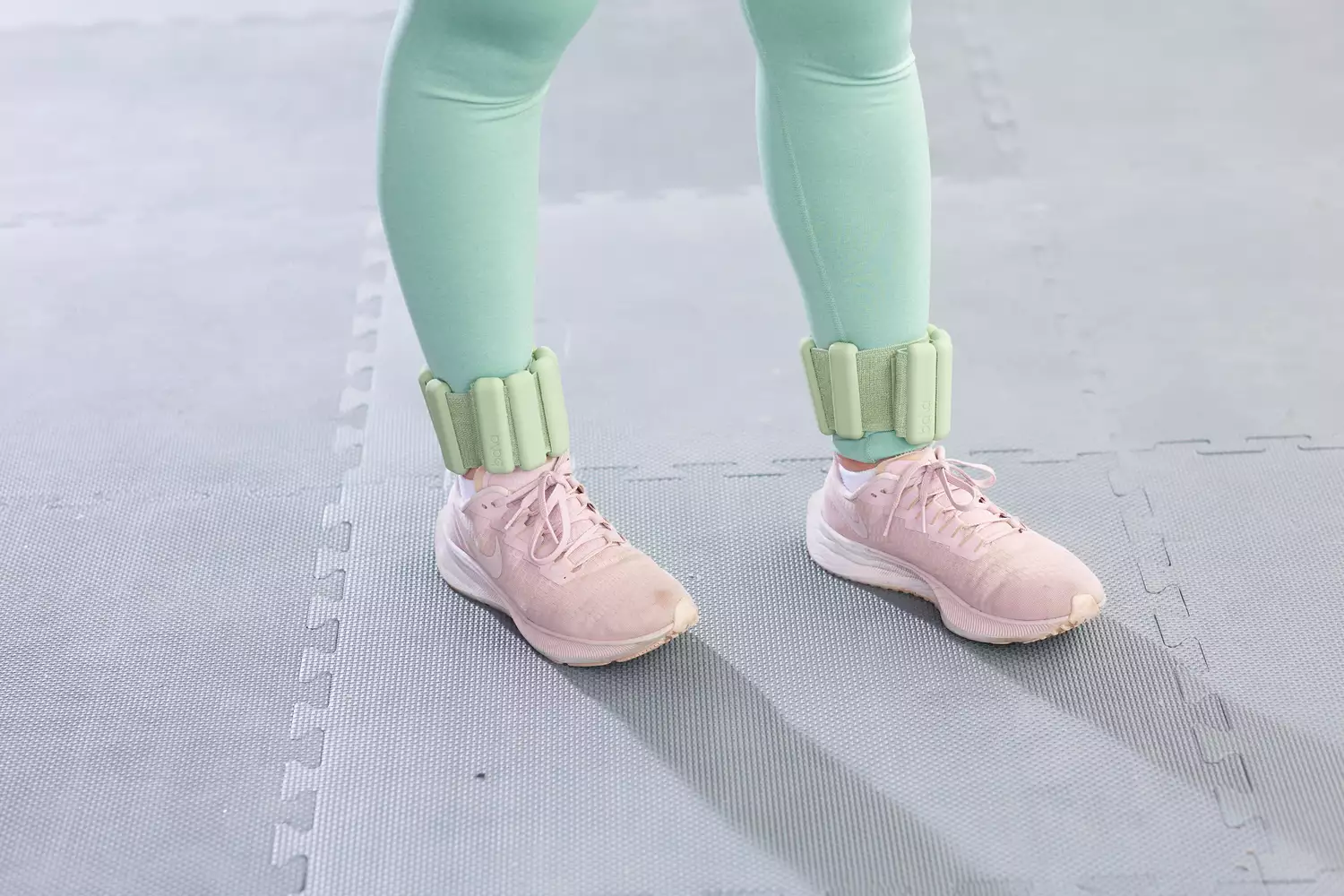 Bala Bangles in a mint green color worn on ankles