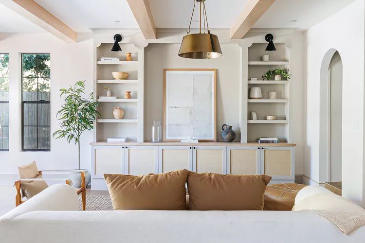 A large living room with white built-in bookshelves.