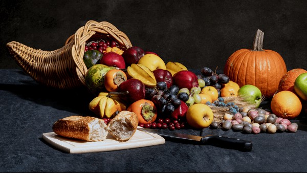 A cornucopia flowing over with fruits, vegetables, and bread.