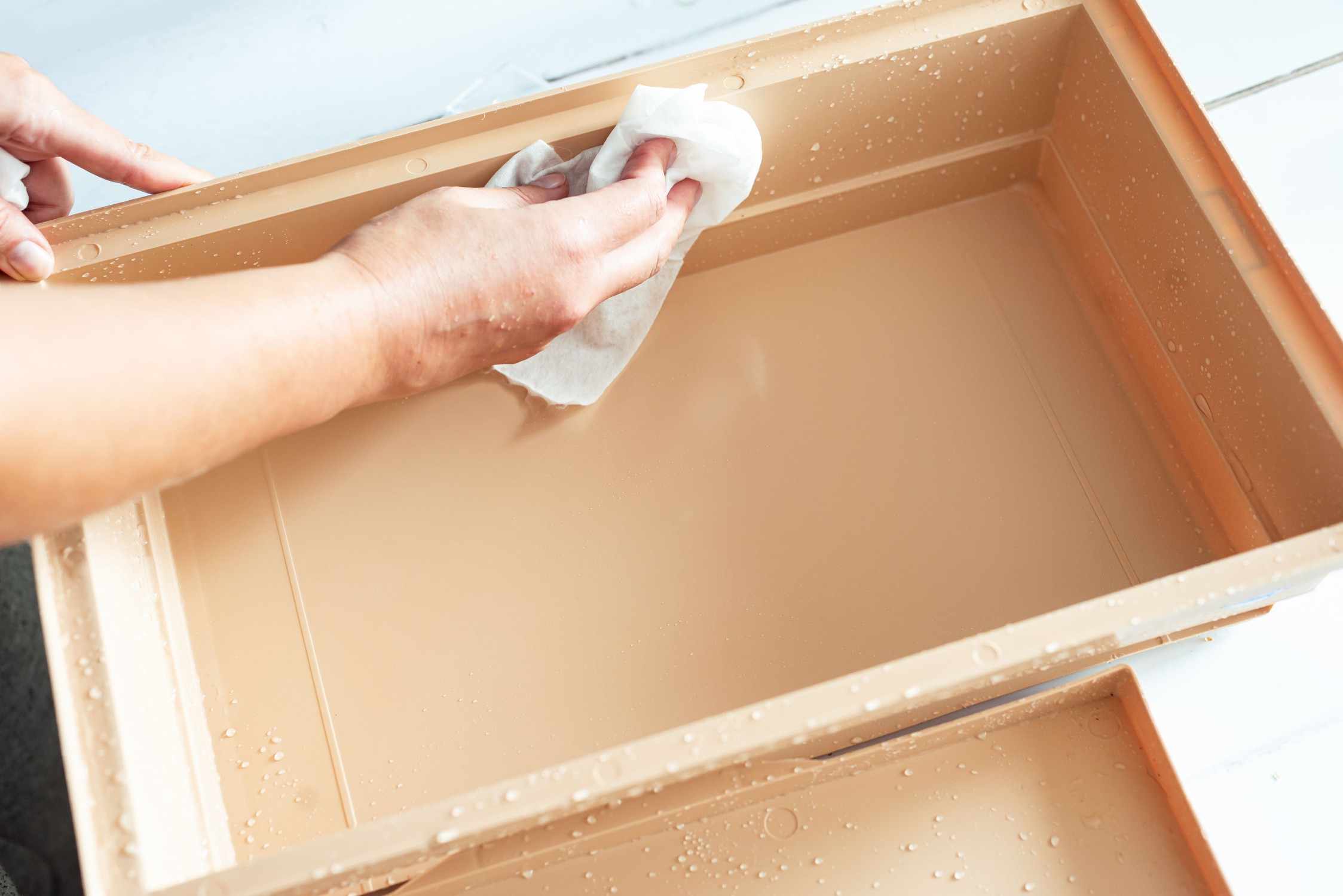 Interior bird cage grate being scrubbed with paper towel 