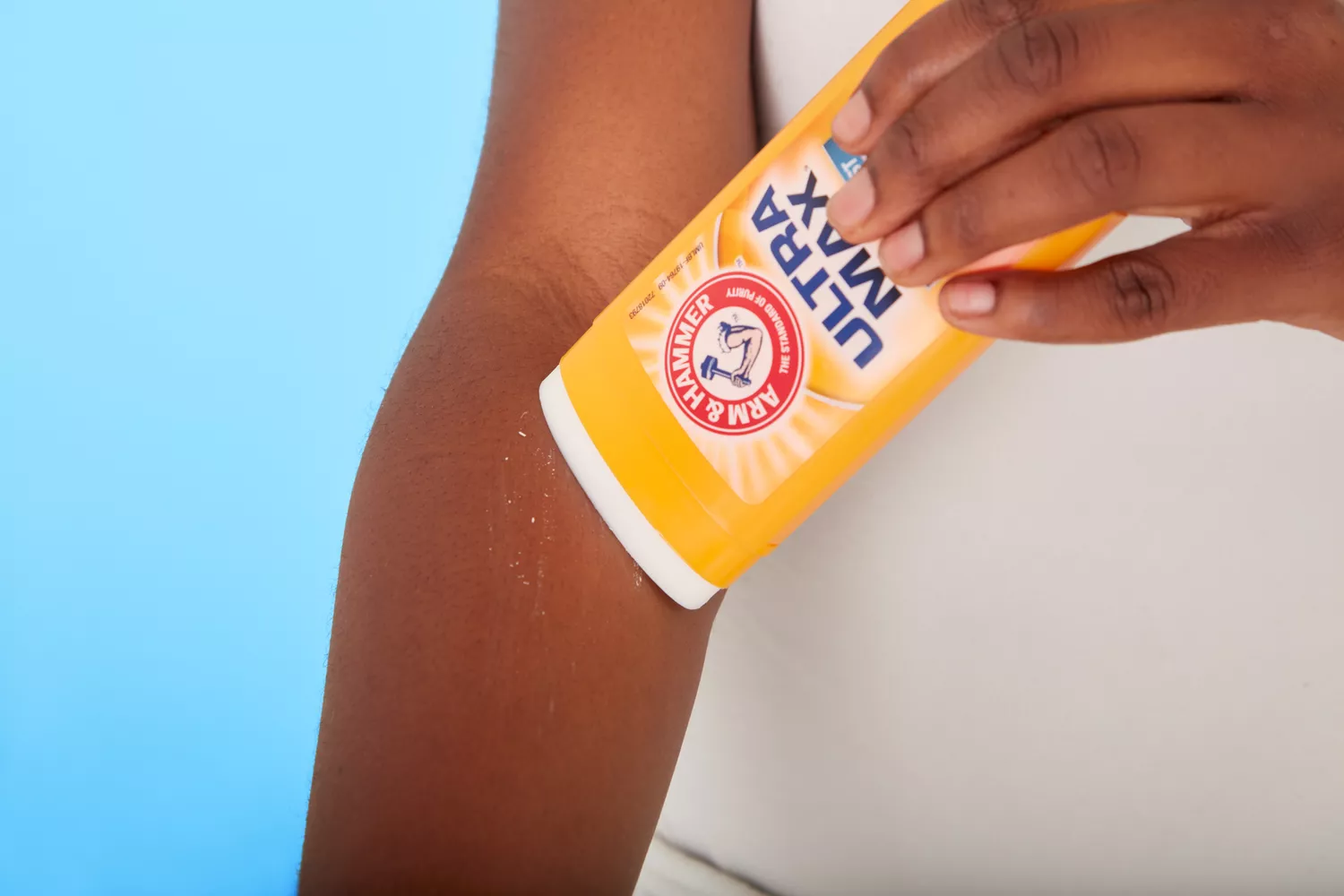 Hand swiping Arm & Hammer Ultra Max on forearm