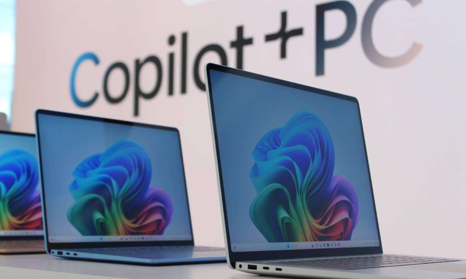 The Surface Laptop shown in front of a Copilot+ sign.