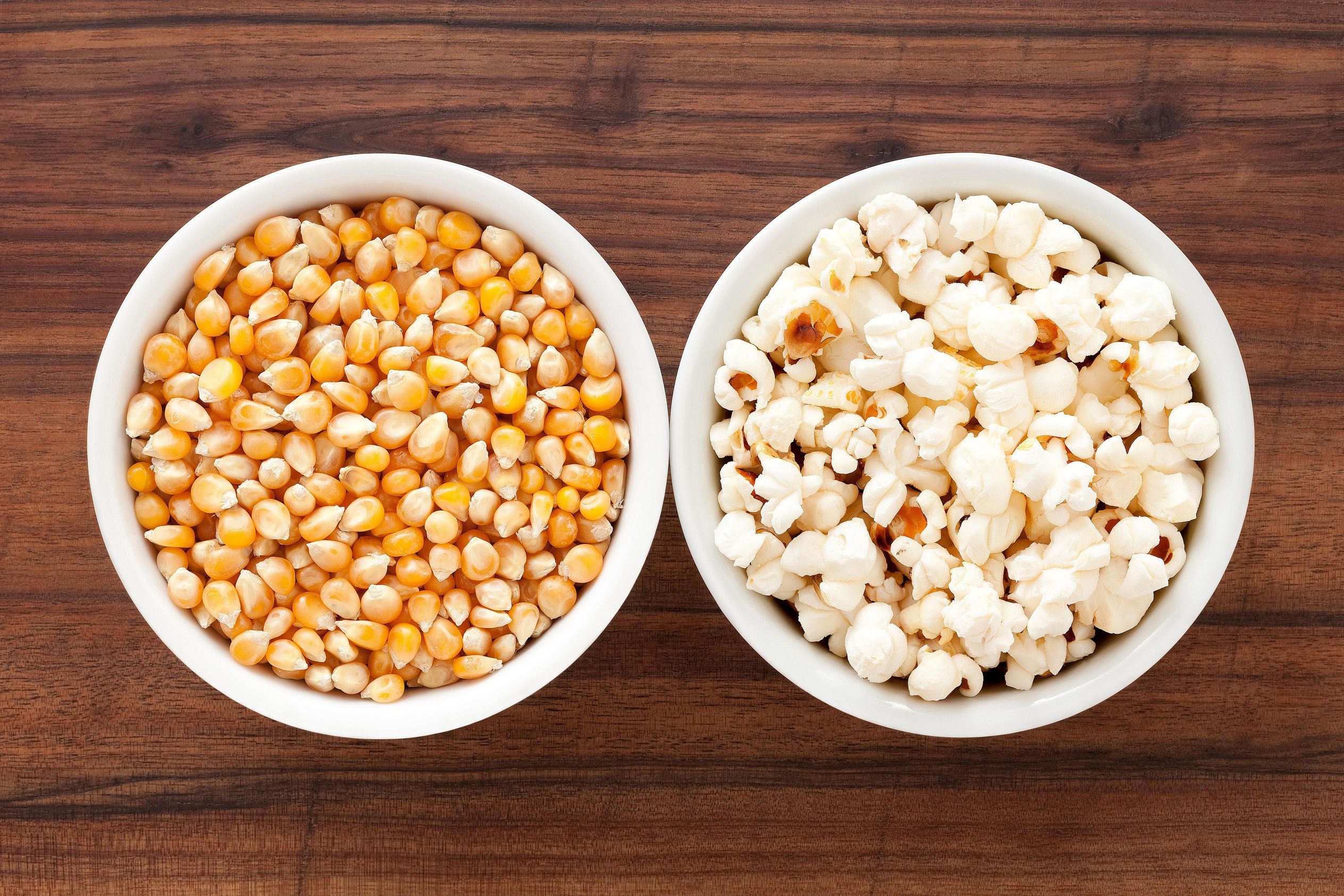 A bowl of corn and a bowl of popcorn