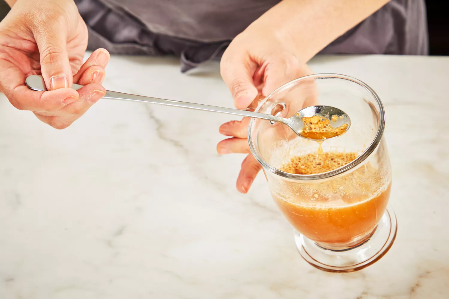 A person stirs Bare Bones Bone Broth Instant Powdered Beverage Mix into water