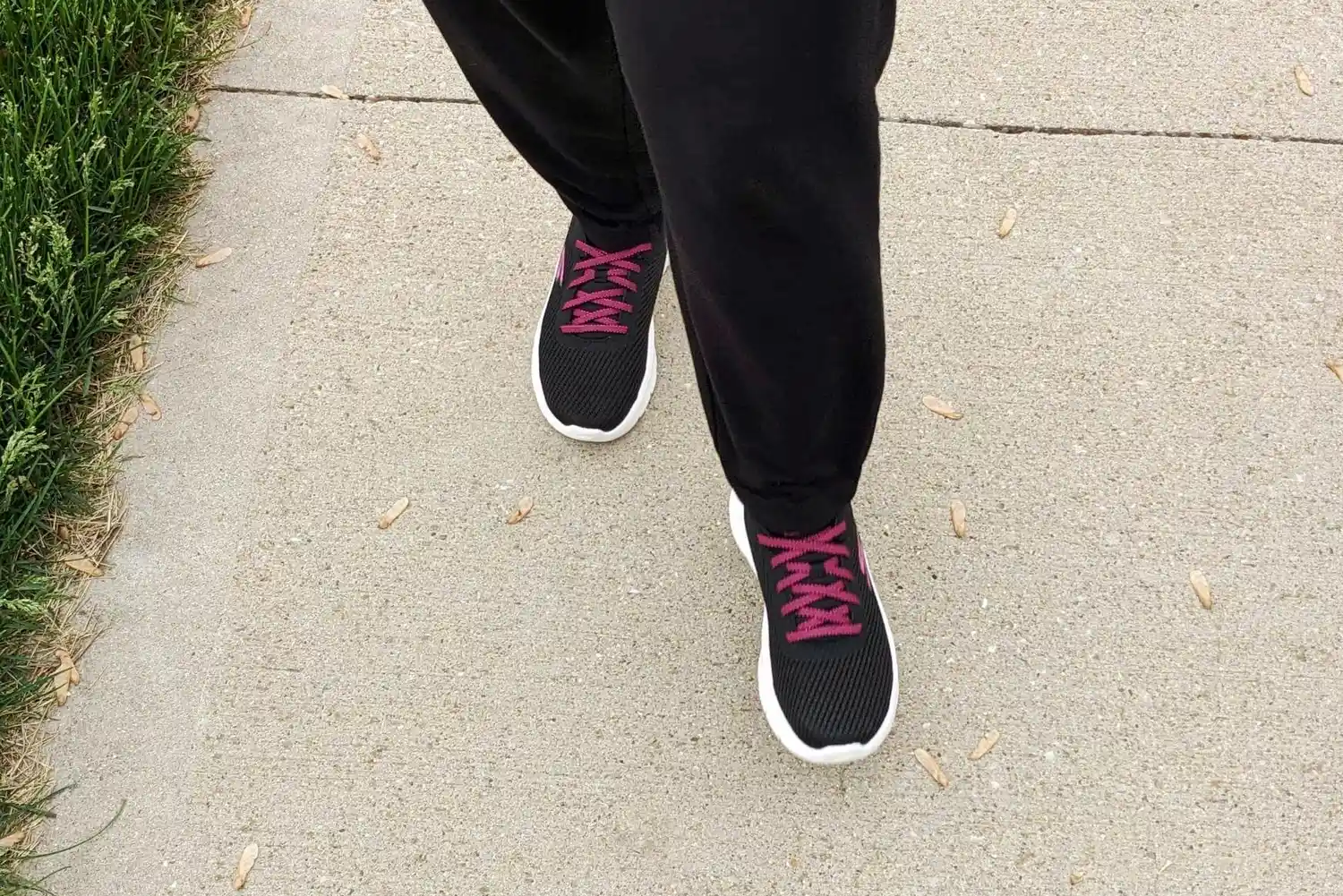 Person wearing Skechers Go Walk Flex Alani Walking Shoes while walking on a sidewalk