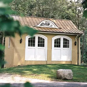 Builder Tim Lee inserted an expressive eyebrow window on the copper roof of a garage-turned-guesthouse in Locust Valley, New York.