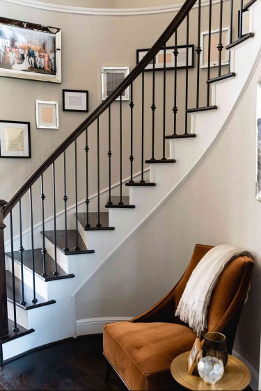A curved staircase with a gallery wall feature