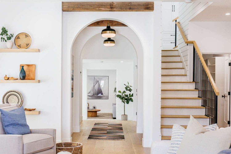 Decorated hallway with white arched walls next to staircase