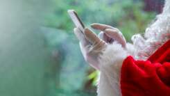 Santa's hands hold a cell phone