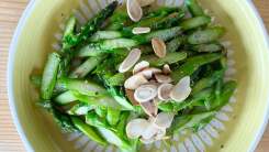 Sautéed asparagus cut on the bias with pepper and almonds on a plate