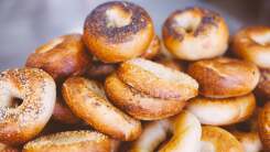 Dozens of assorted bagels piled on top of each other.