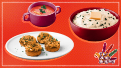 A bowl of mashed potatoes, next to soup and stuffed mushrooms.