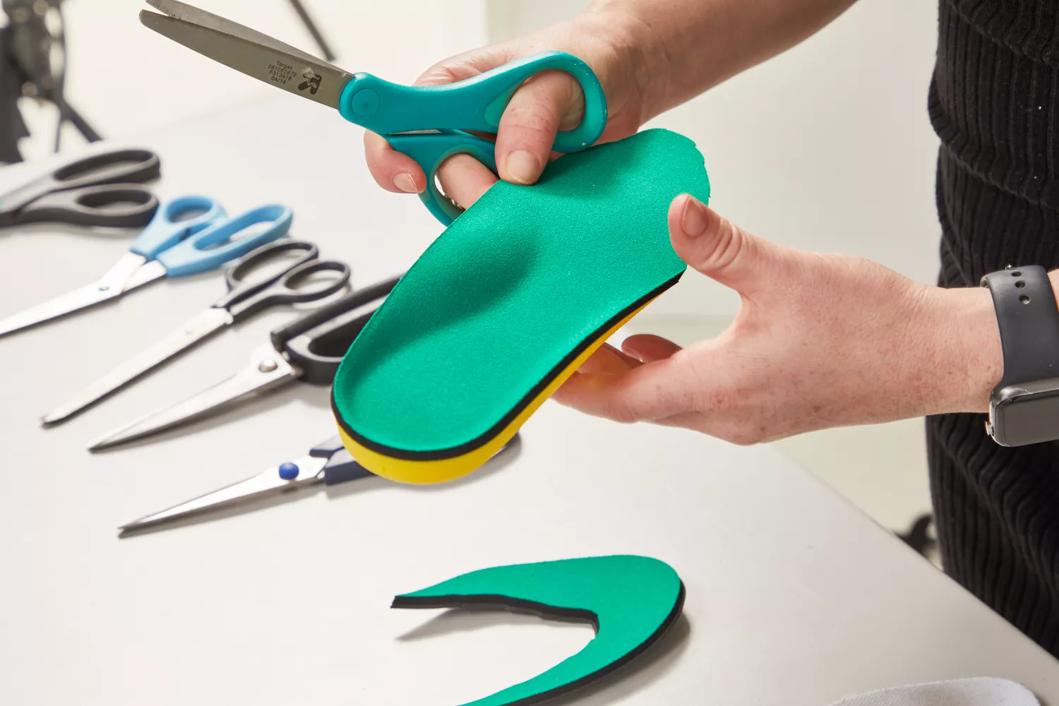 Hands trimming a Spenco PolySorb Cross Trainer Insole