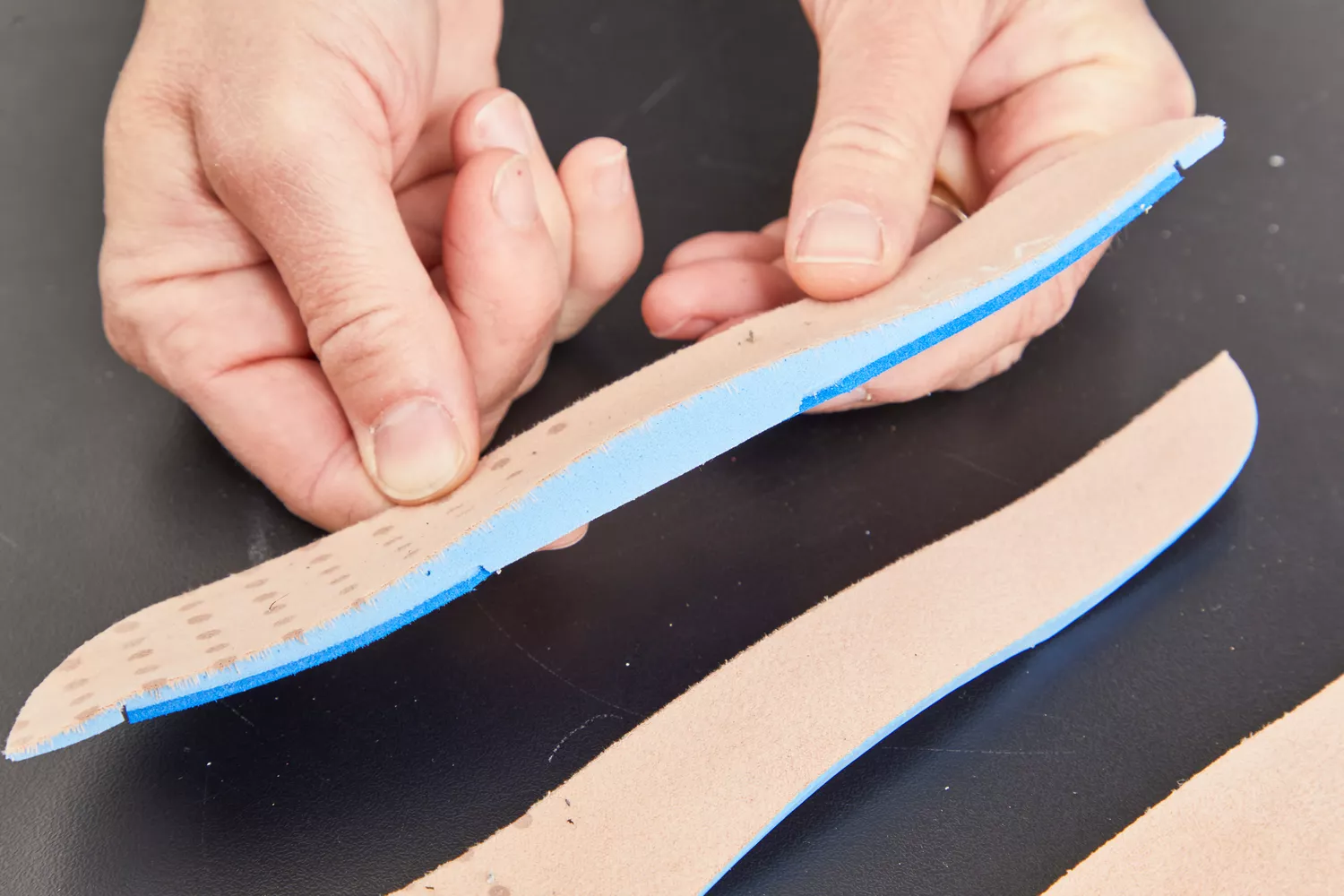 Hands holding half of a Vionic Slimfit Orthotic Insoles