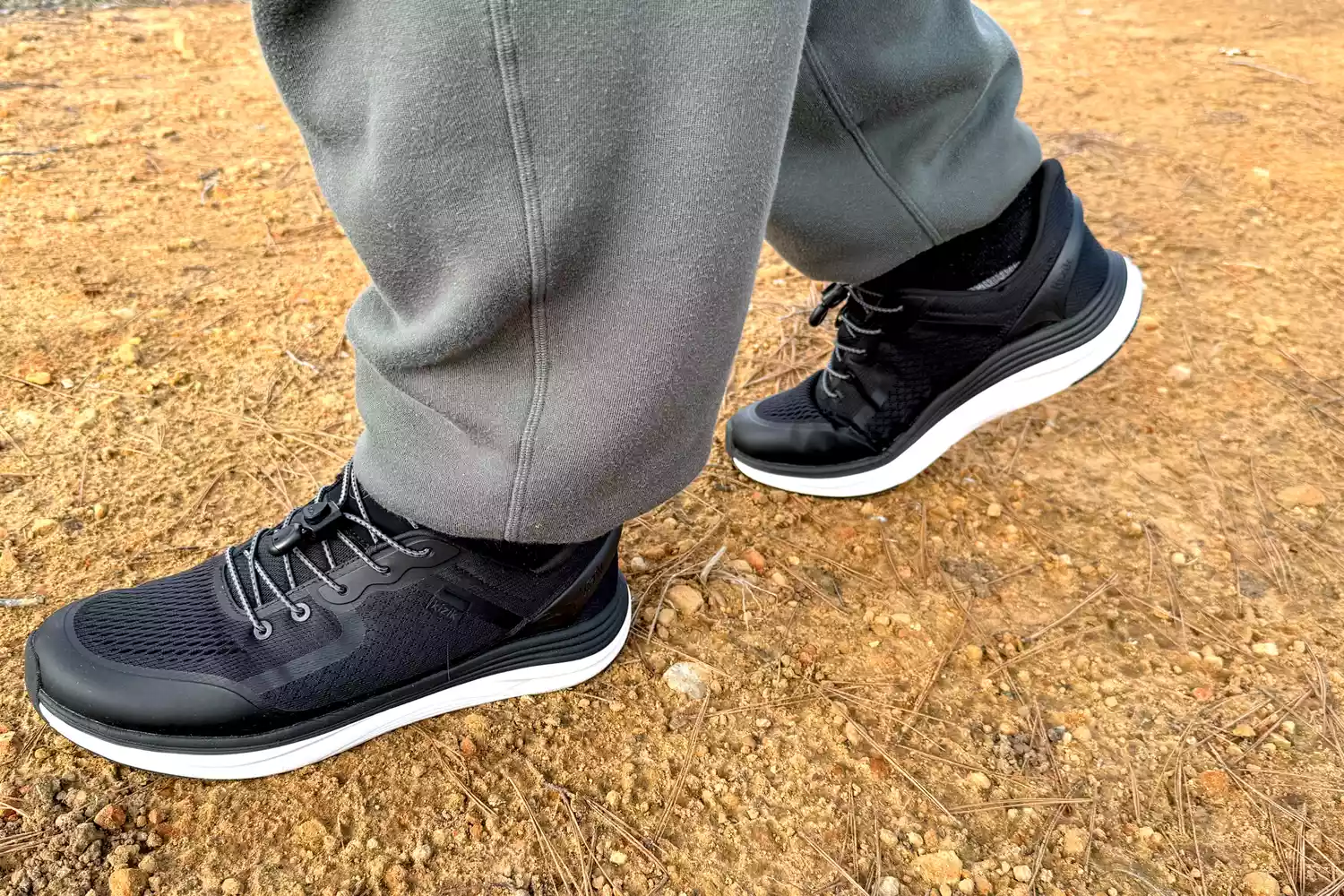 The side view of a person walking while wearing the Kizik Men's London Sneakers