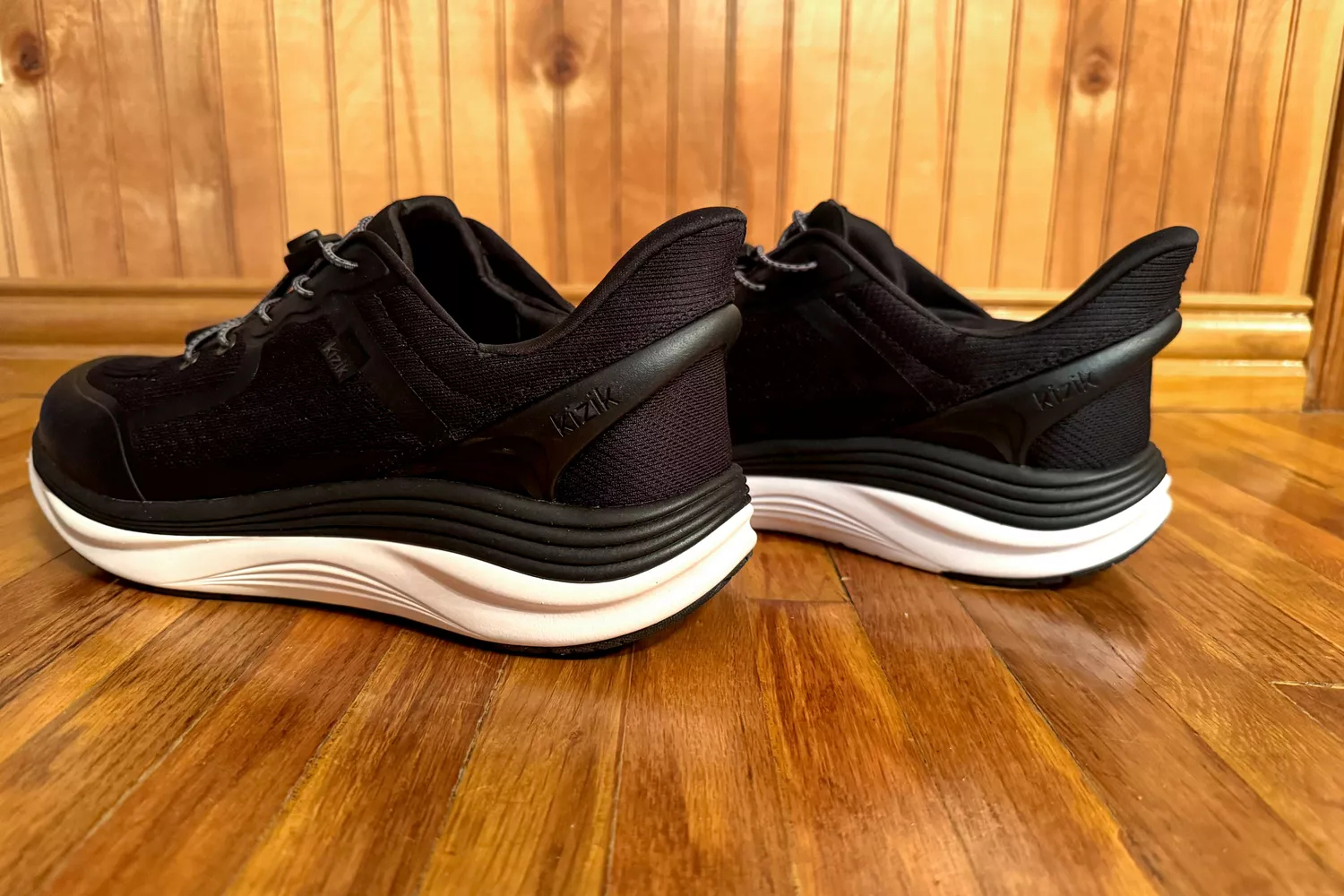 The side-view of the Kizik Men's London Sneakers on wood